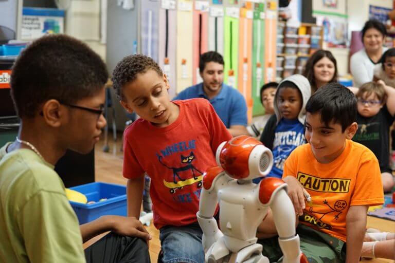 Students working and learning with a robot